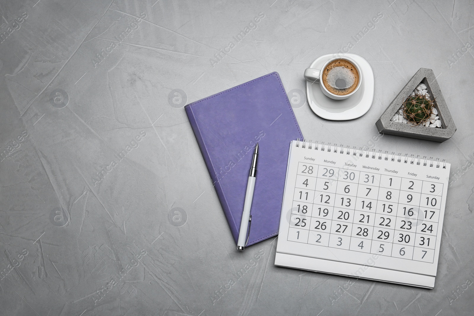 Photo of Flat lay composition with calendar and cup of coffee on grey table. Space for text