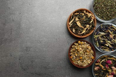 Photo of Flat lay composition with different dry teas on grey table, space for text