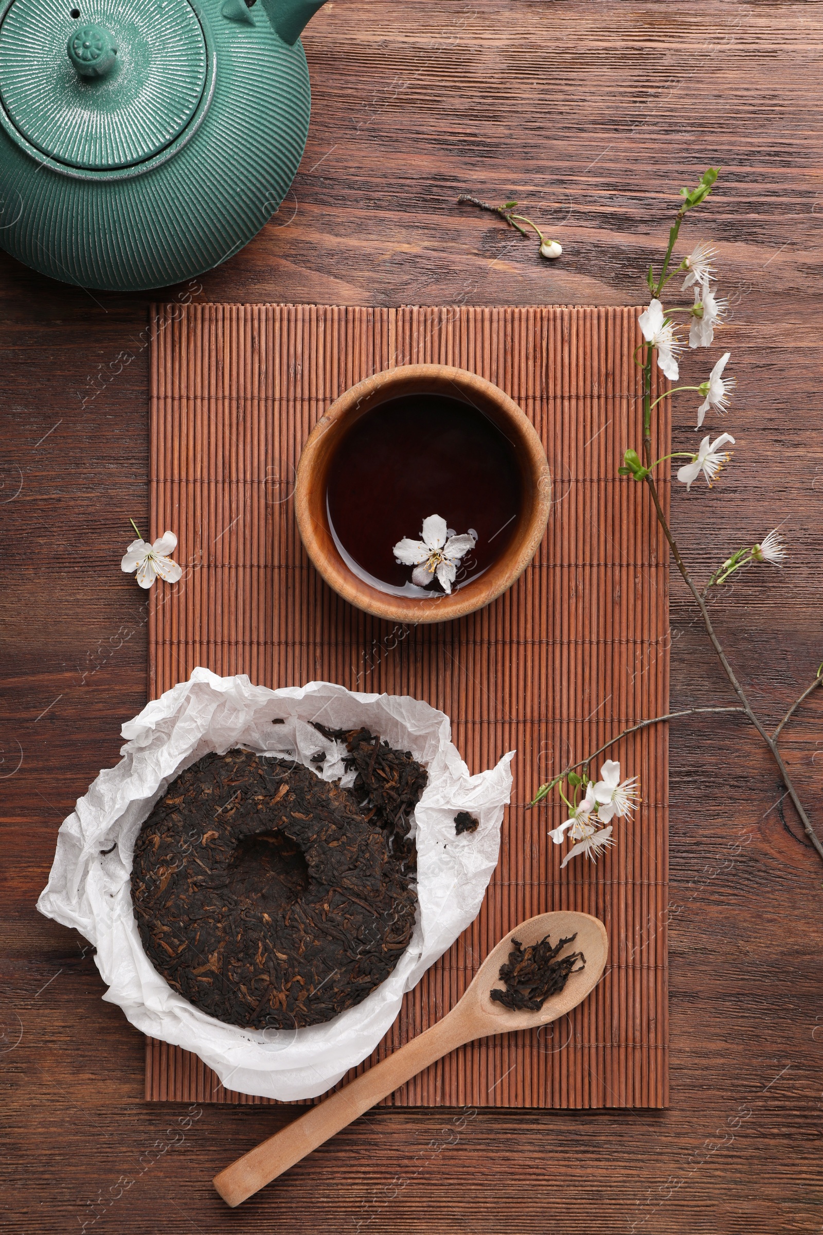 Photo of Flat lay composition with aromatic pu-erh tea on wooden table