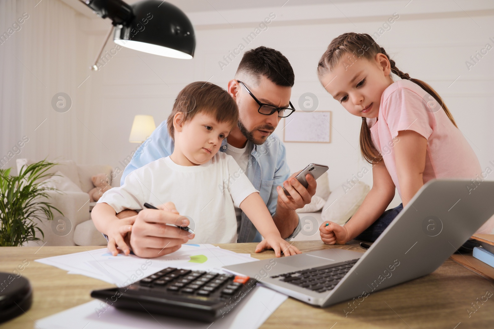 Photo of Overwhelmed man combining parenting and work at home