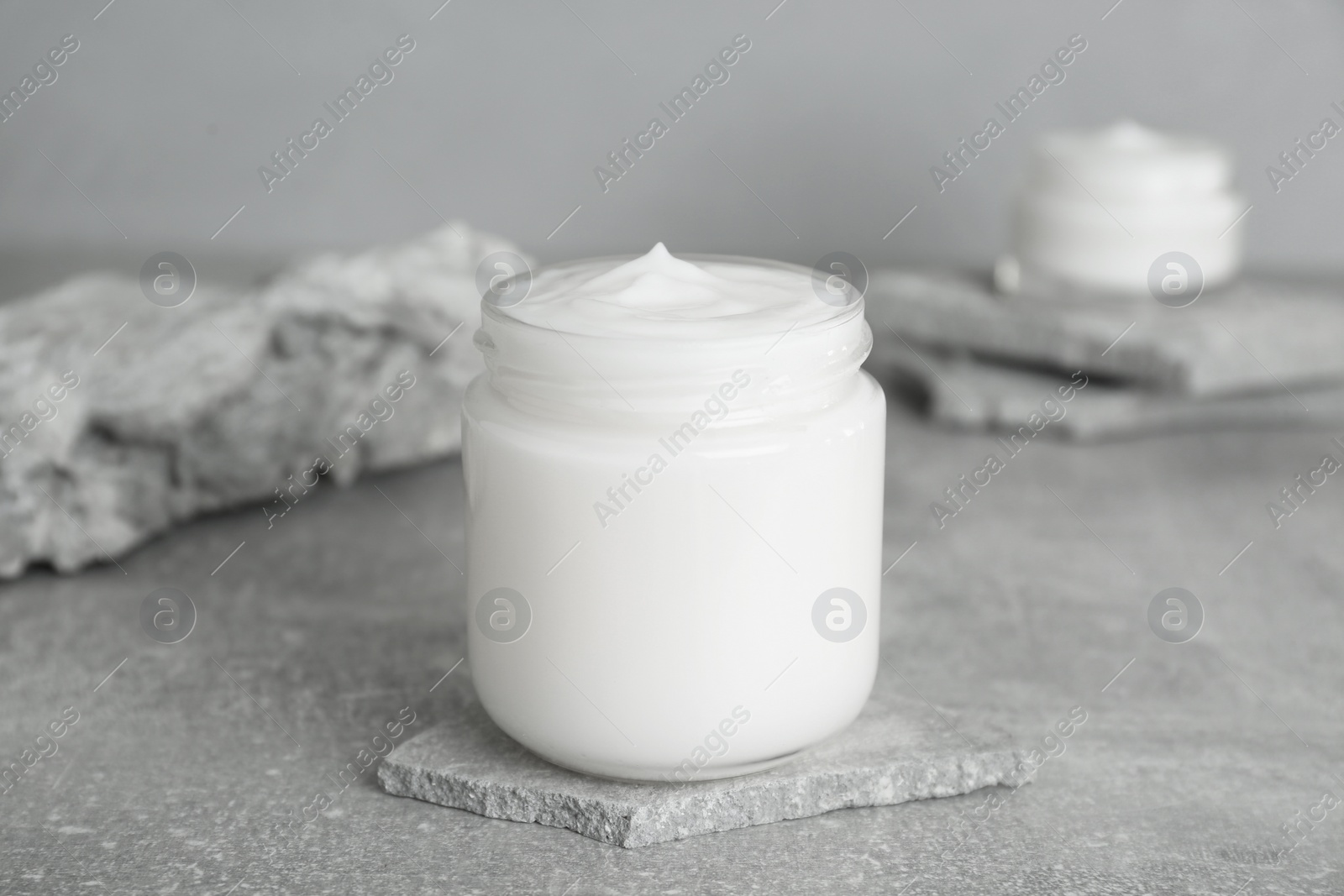 Photo of Jar of hand cream on gray marble table