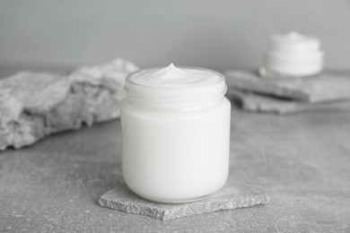 Photo of Jar of hand cream on gray marble table