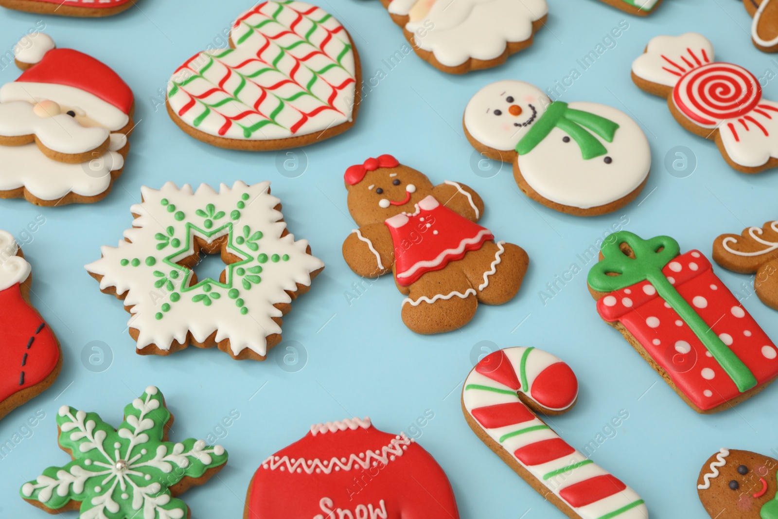 Photo of Different Christmas gingerbread cookies on light blue background, closeup