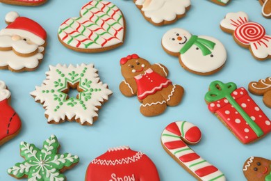 Different Christmas gingerbread cookies on light blue background, closeup