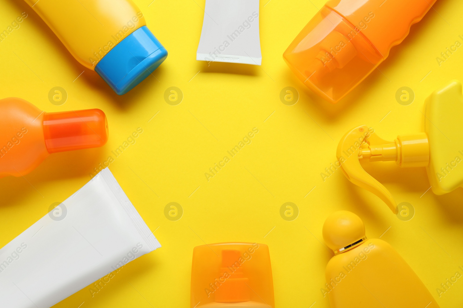 Photo of Suntan products on yellow background, flat lay. Space for text