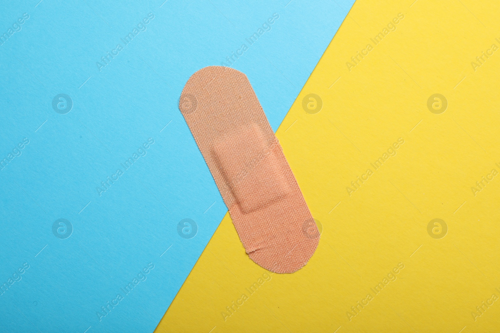 Photo of Sticking plaster on color background, top view