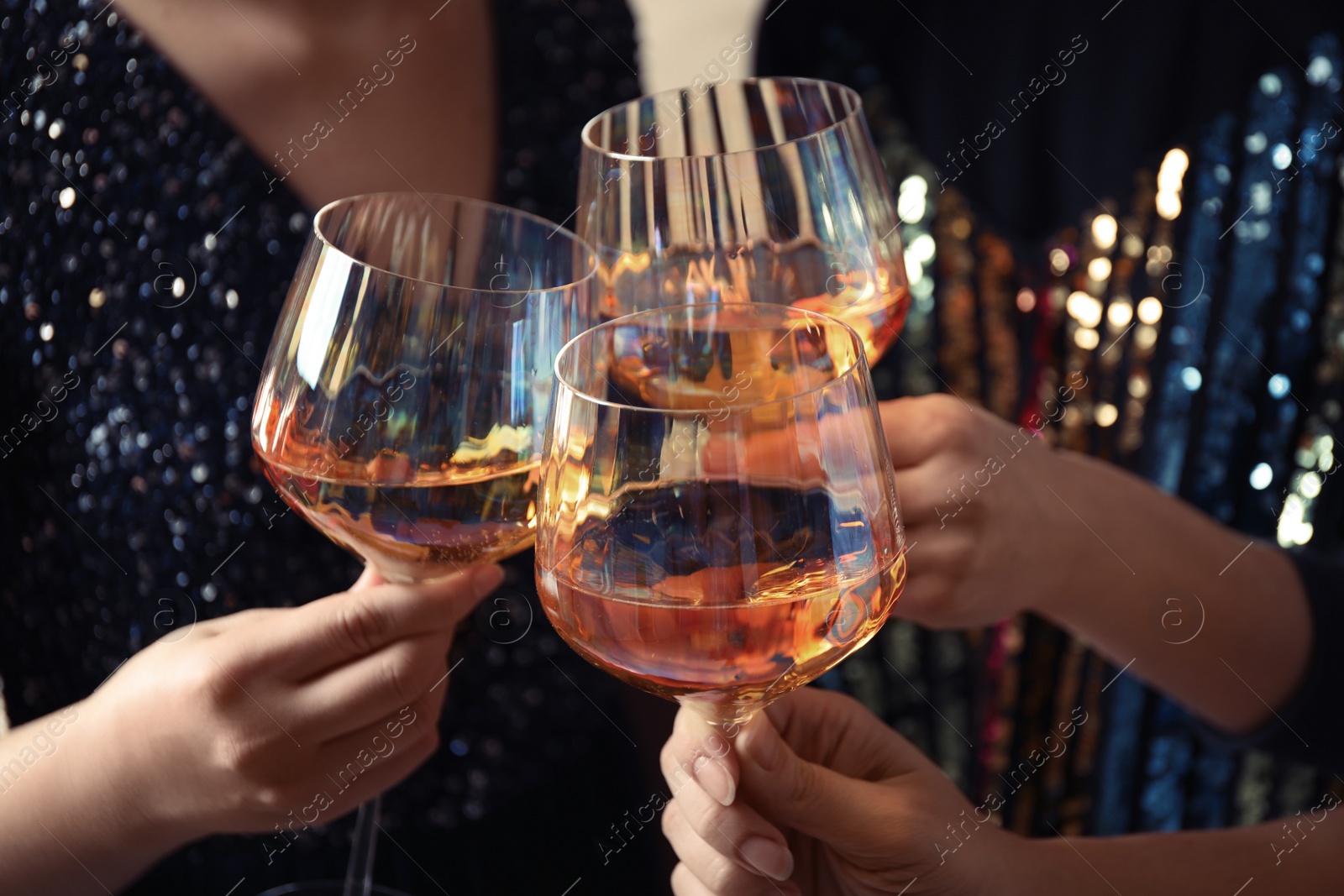 Photo of Women clinking glasses with white wine, closeup