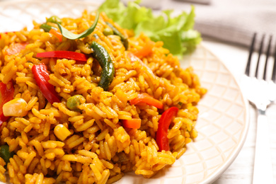 Delicious rice pilaf with vegetables on white table, closeup