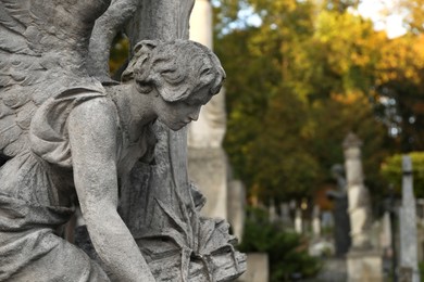 Photo of Beautiful statue of angel at cemetery, space for text. Funeral ceremony