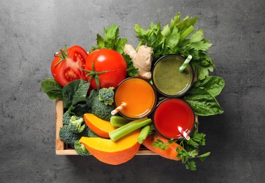 Photo of Delicious vegetable juices and fresh ingredients on grey table, top view