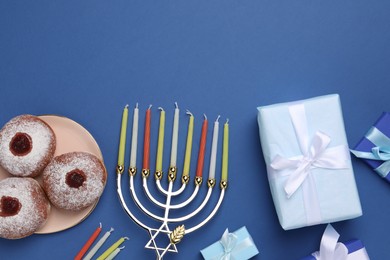 Photo of Flat lay composition with Hanukkah menorah and donuts on blue background, space for text