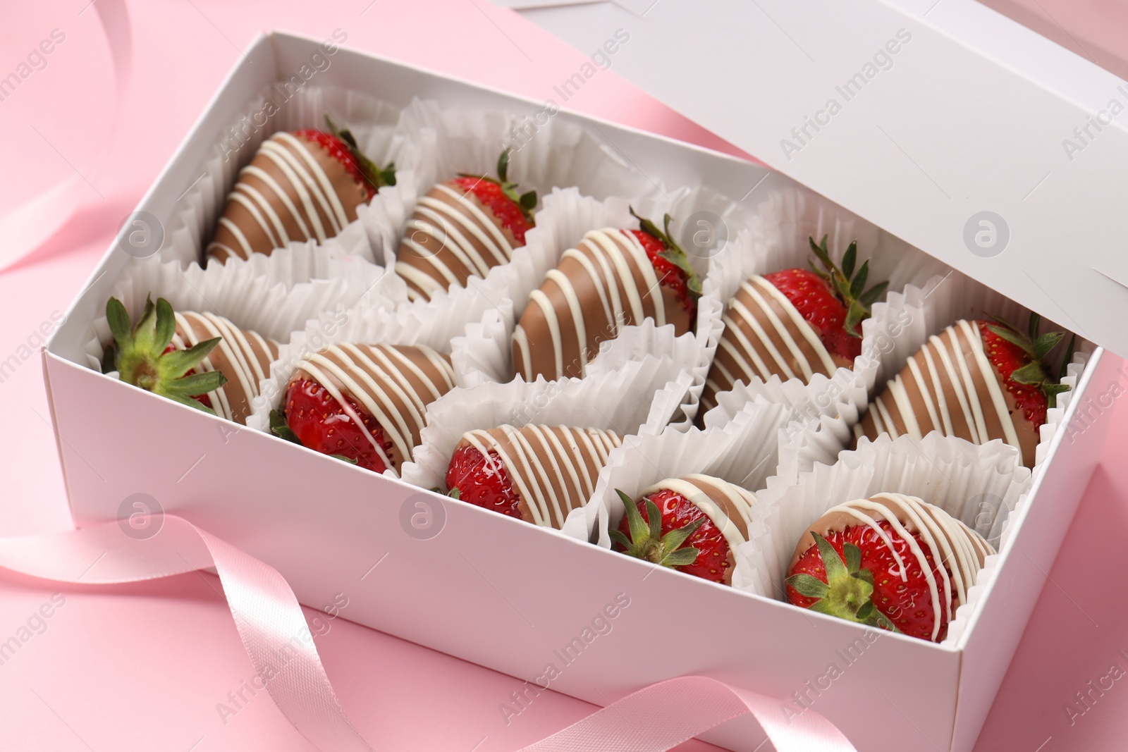 Photo of Box with delicious chocolate covered strawberries on pink background, closeup