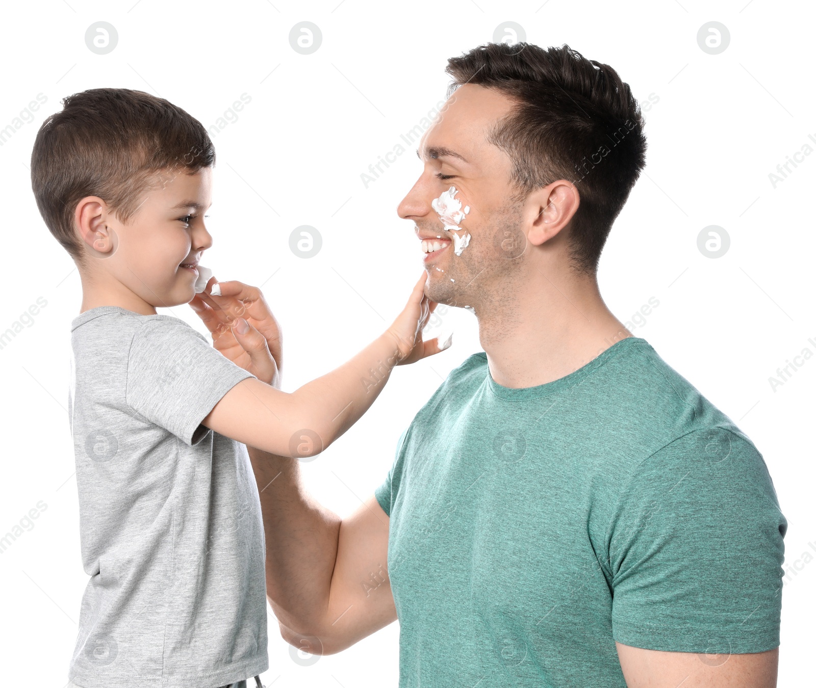 Photo of Dad and his little son applying shaving foam against white background