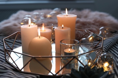 Tray with burning candles on striped fabric