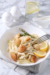 Photo of Delicious scallop pasta served on white marble table