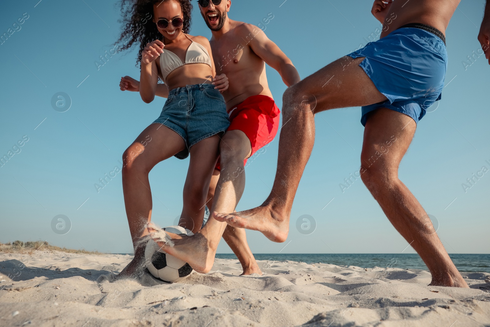 Photo of Group of friends playing football on beach