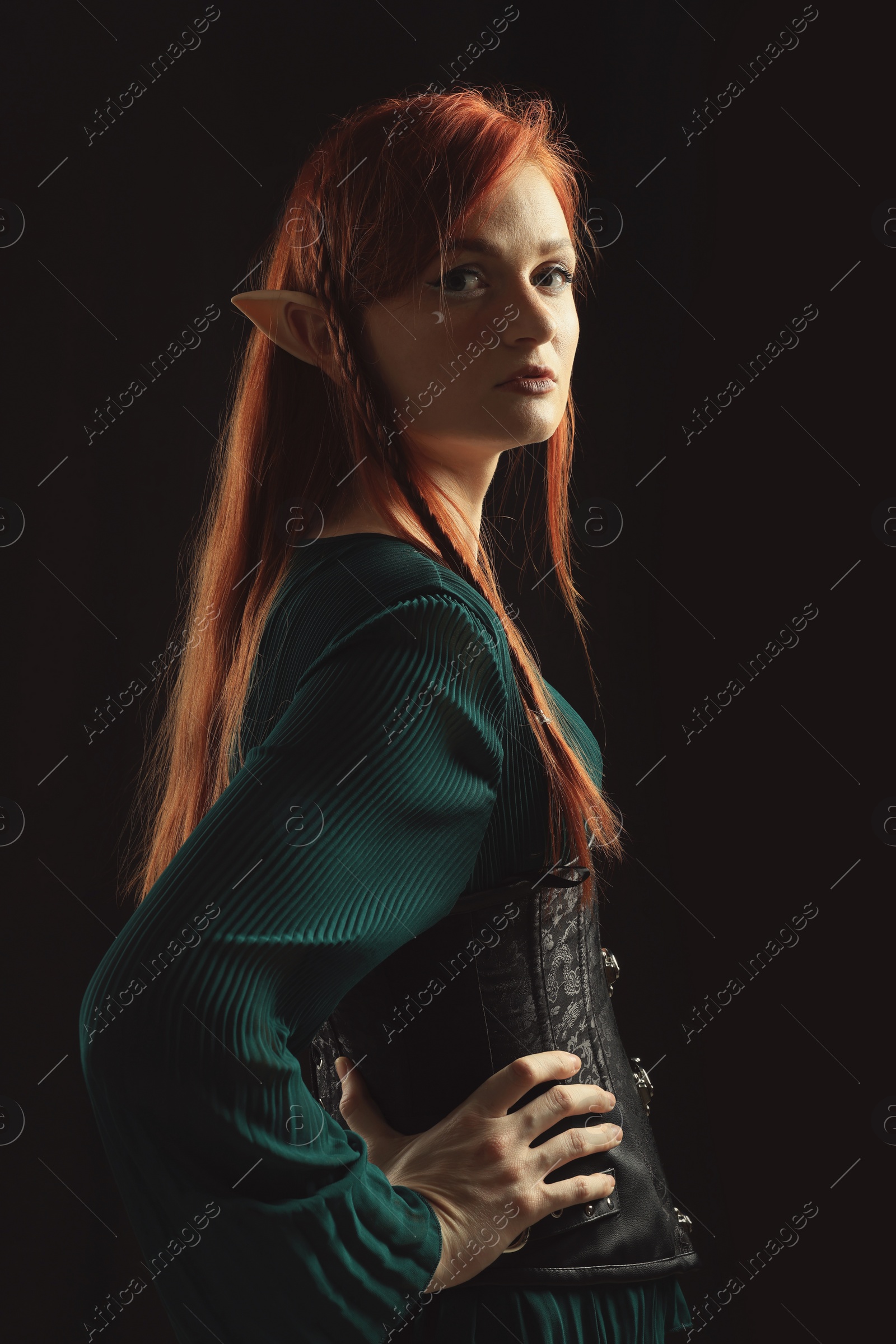 Photo of Beautiful redhead elf girl on black background