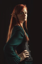 Beautiful redhead elf girl on black background