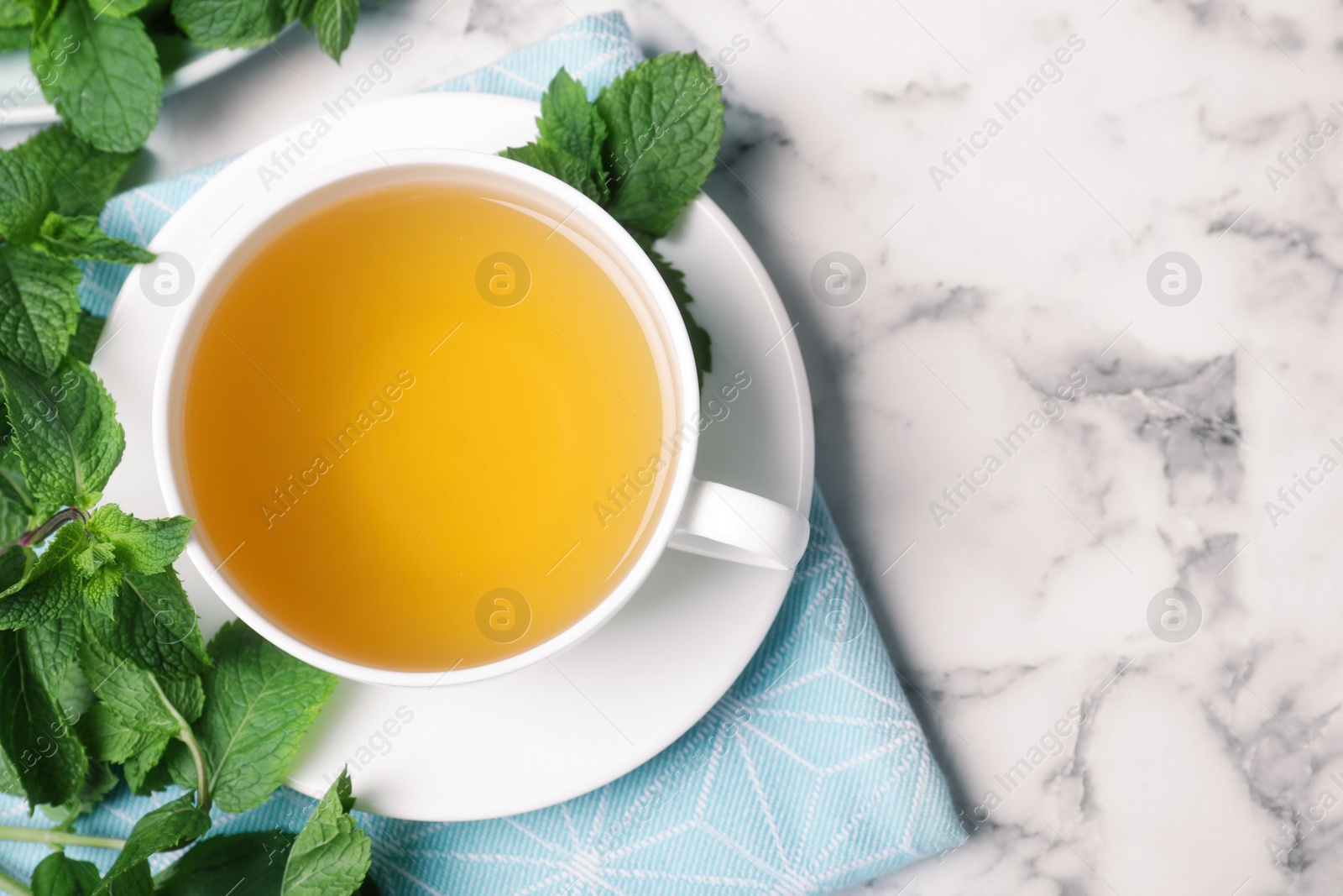 Photo of Fresh tea with mint on white marble table, flat lay