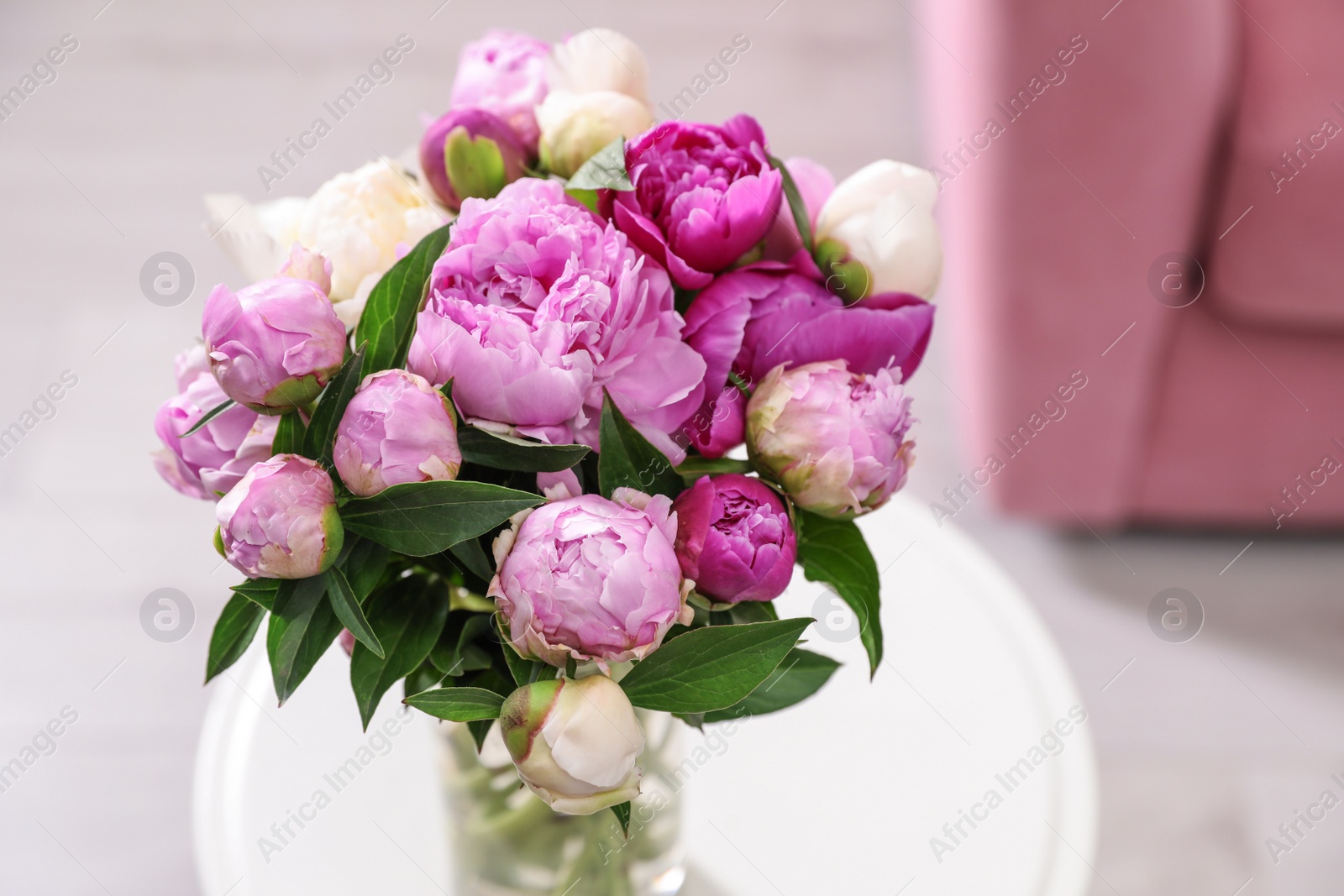 Photo of Vase with bouquet of beautiful peonies on table in room, above view. Space for text