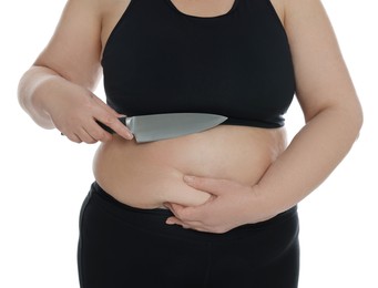 Photo of Obese woman with knife on white background, closeup. Weight loss surgery