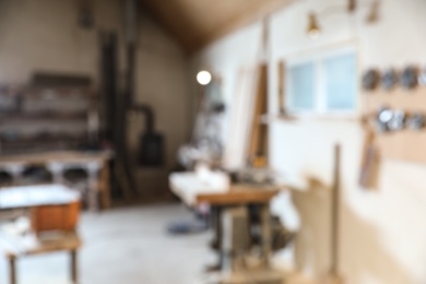 Photo of Blurred view of carpentry shop interior. Working space