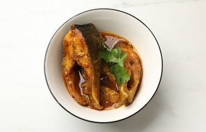 Photo of Tasty fish curry on white marble table, top view. Indian cuisine