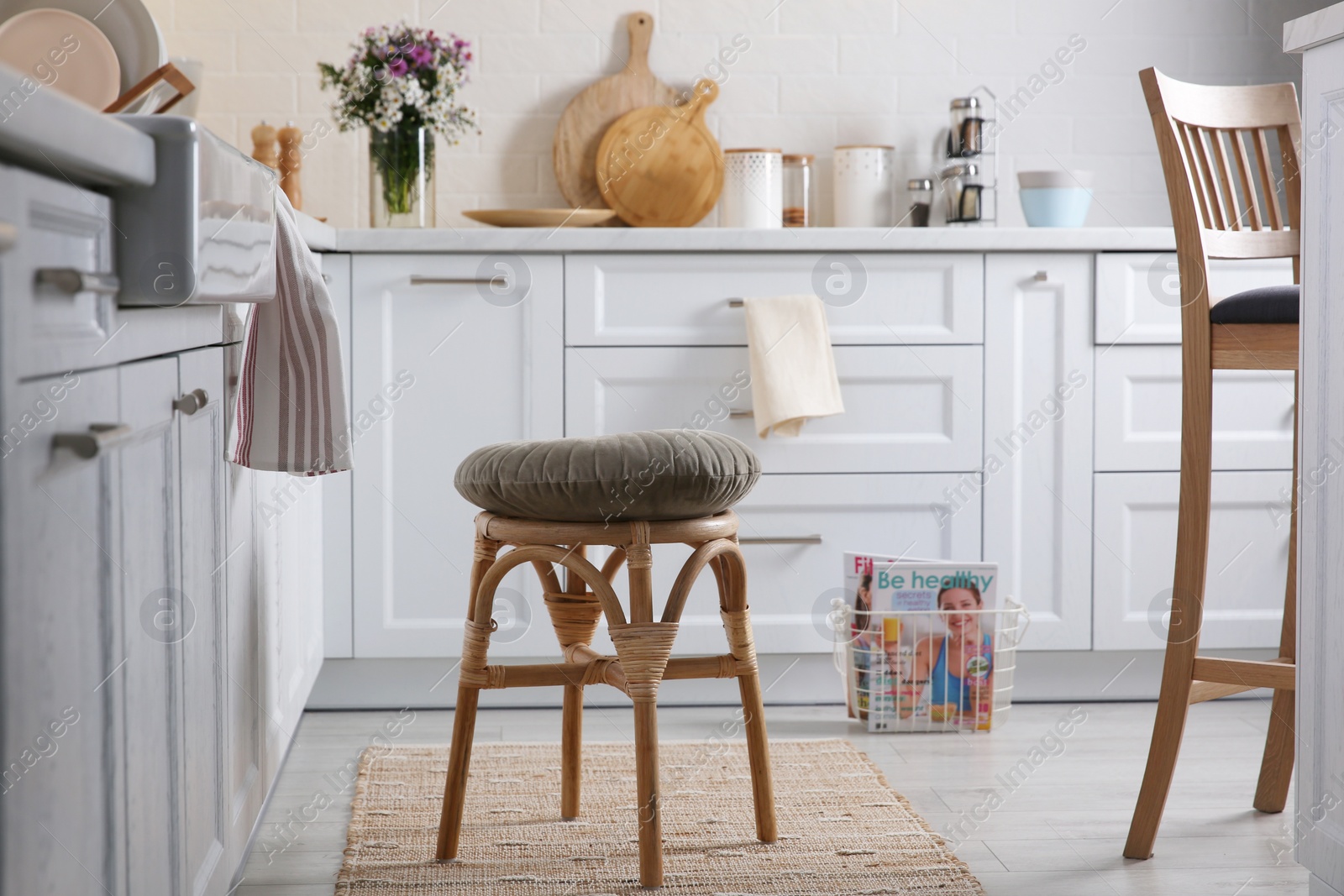 Photo of Stylish kitchen interior with wooden stool and other furniture