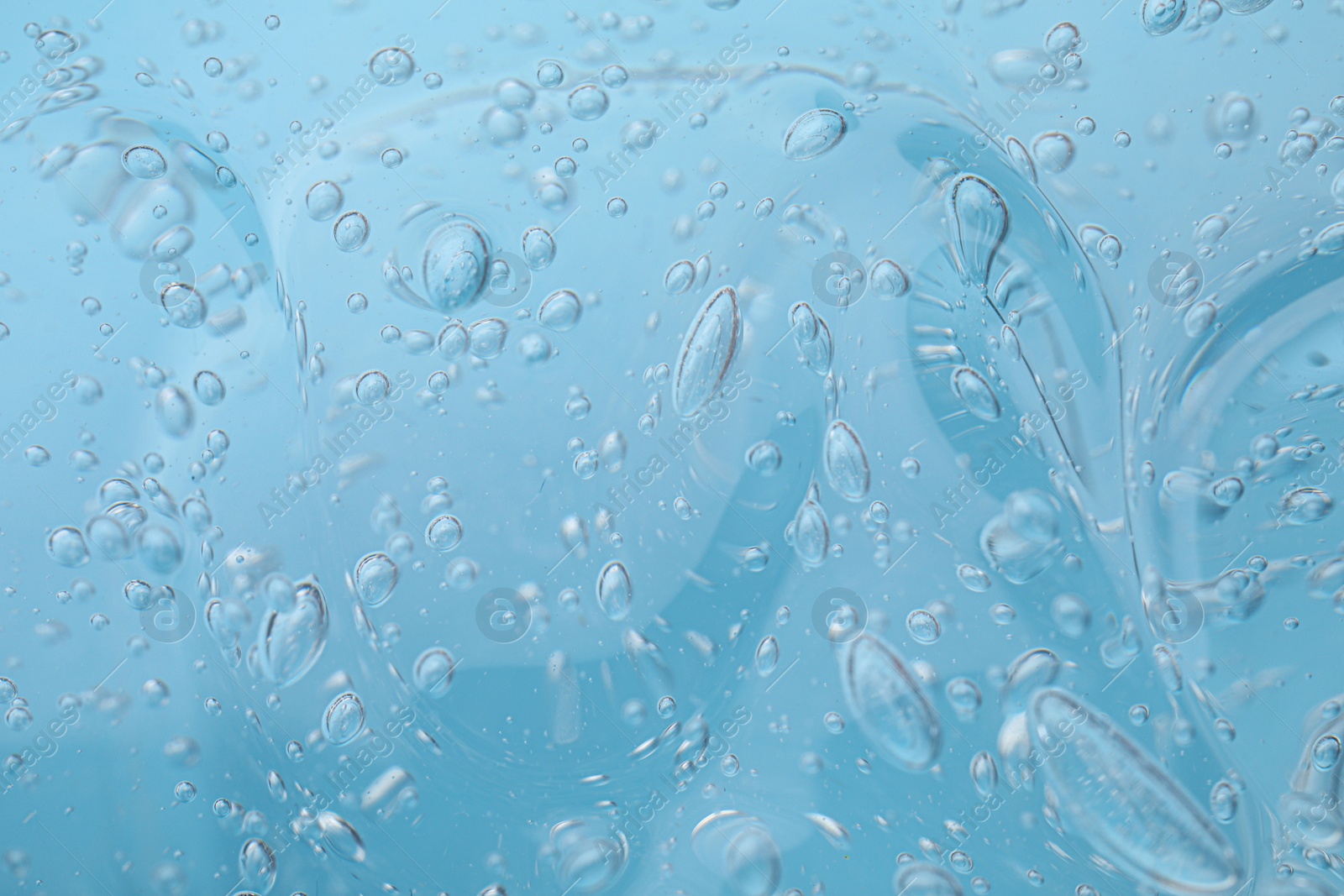 Photo of Sample of light blue cosmetic gel as background, closeup