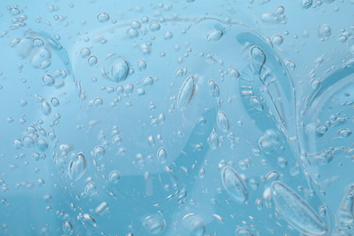 Photo of Sample of light blue cosmetic gel as background, closeup