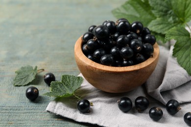 Photo of Ripe blackcurrants and leaves on wooden rustic table