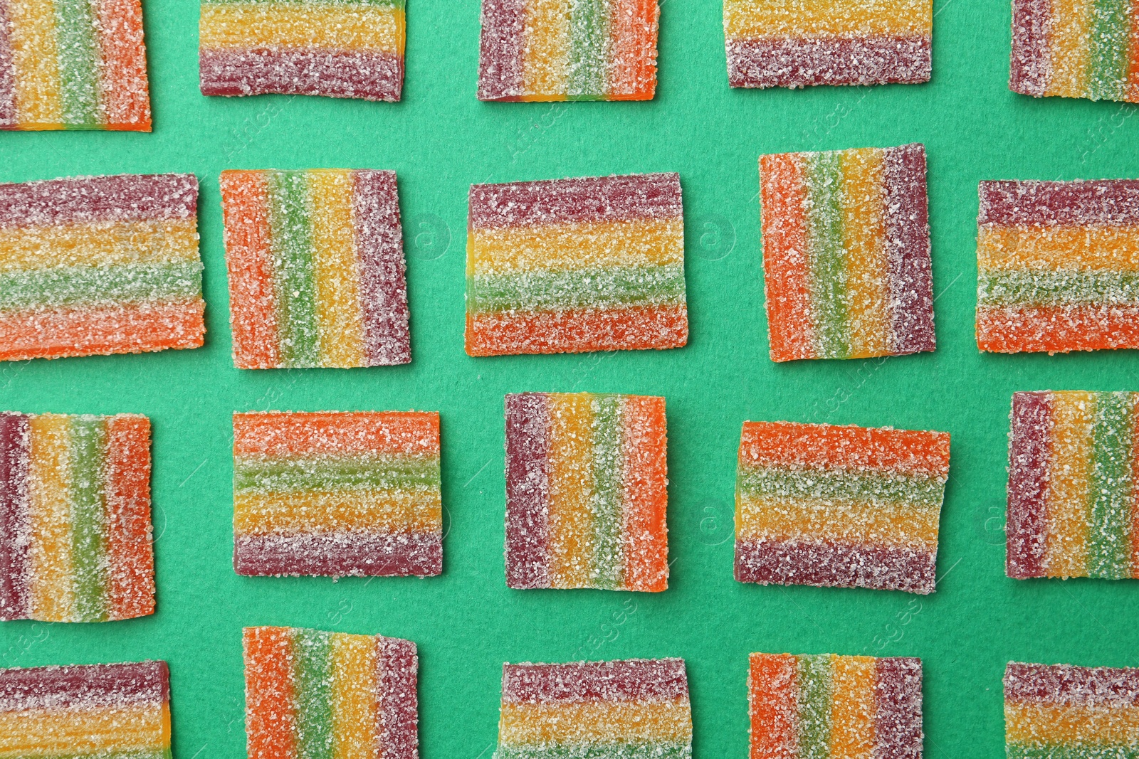 Photo of Flat lay composition with delicious jelly candies on color background