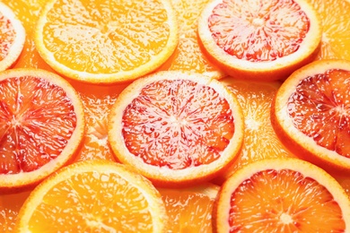 Photo of Slices of fresh citrus fruits as background, closeup