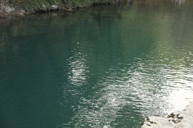 Photo of Picturesque view of clean pond near stones outdoors