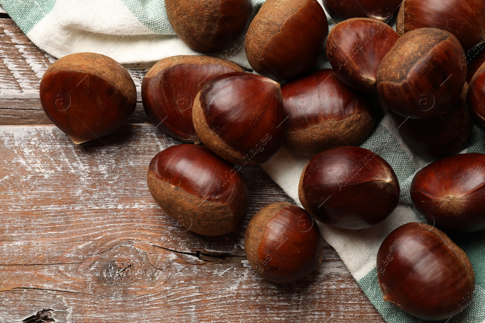 Photo of Sweet fresh edible chestnuts on wooden table, top view