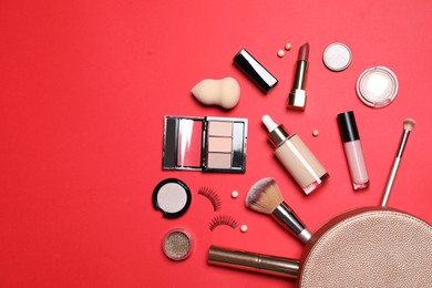 Photo of Different makeup products with cosmetic bag on red background, flat lay. Space for text