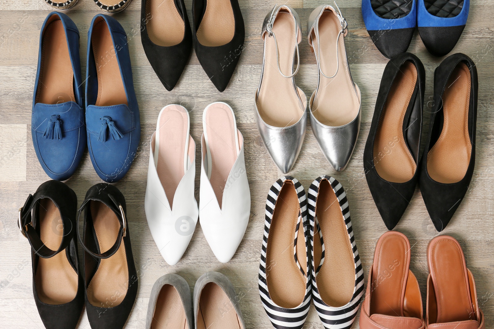 Photo of Different female shoes on wooden background, top view