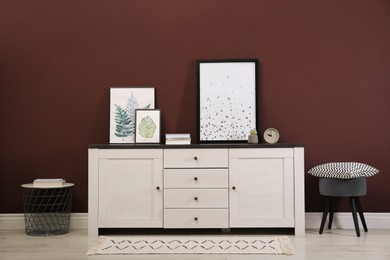 Photo of Modern room interior with chest of drawers near brown wall