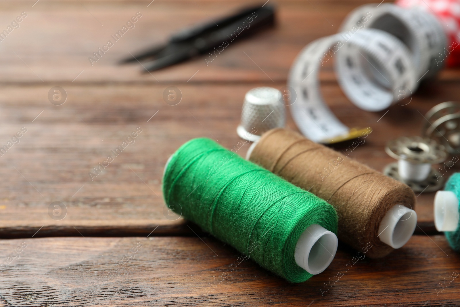 Photo of Threads and other sewing supplies on wooden table