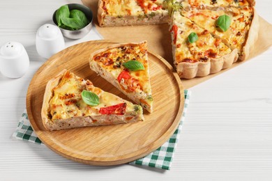 Photo of Tasty quiche with tomatoes, basil and cheese on white wooden table
