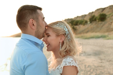 Wedding couple. Groom kissing bride on beach