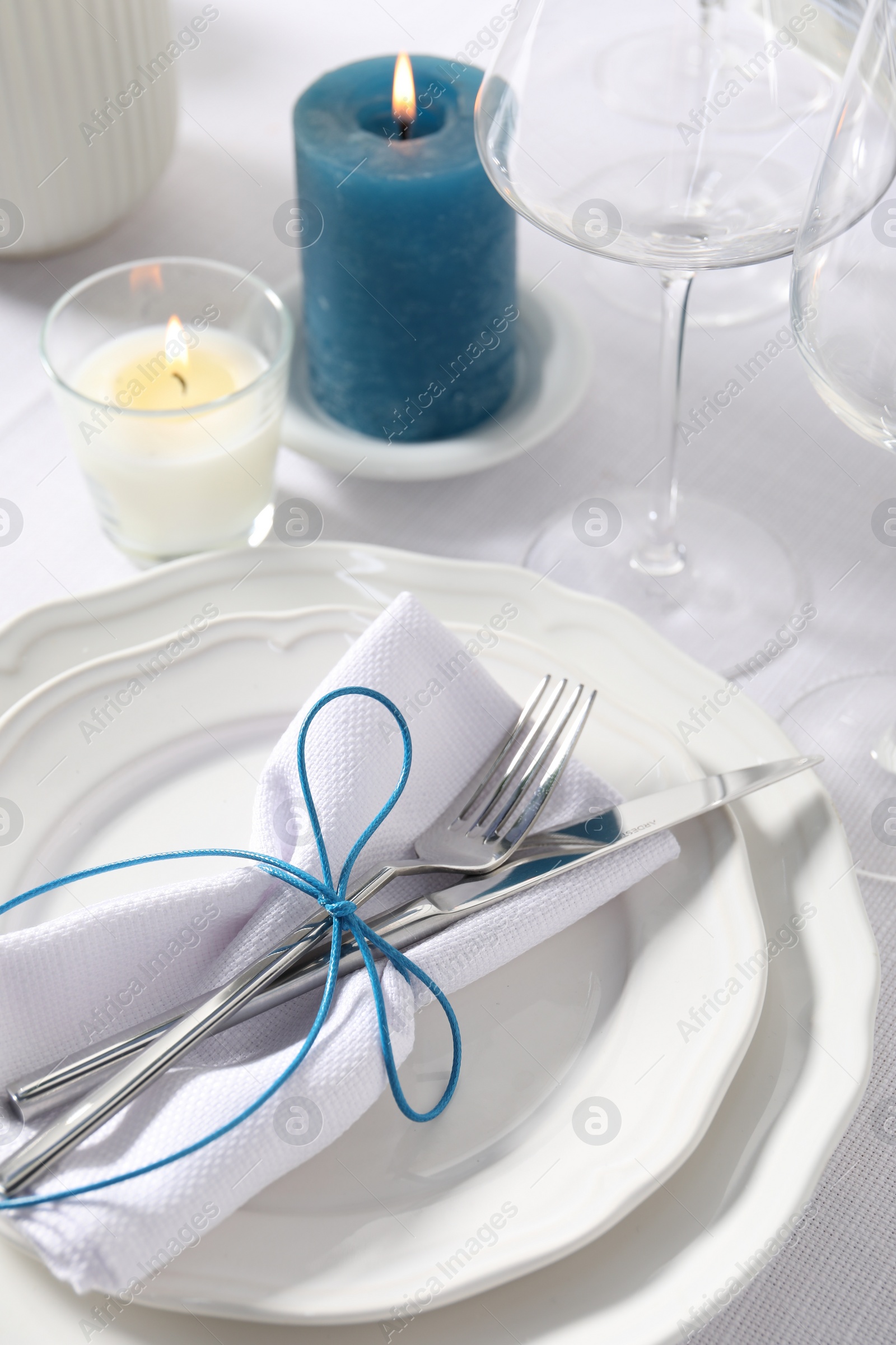 Photo of Beautiful table setting with silverware and candles, closeup