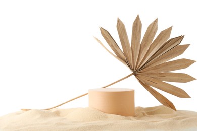 Photo of Presentation of product. Beige podium and palm leaf on sand against white background