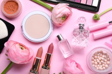 Photo of Flat lay composition with different makeup products and beautiful spring flowers on pink background