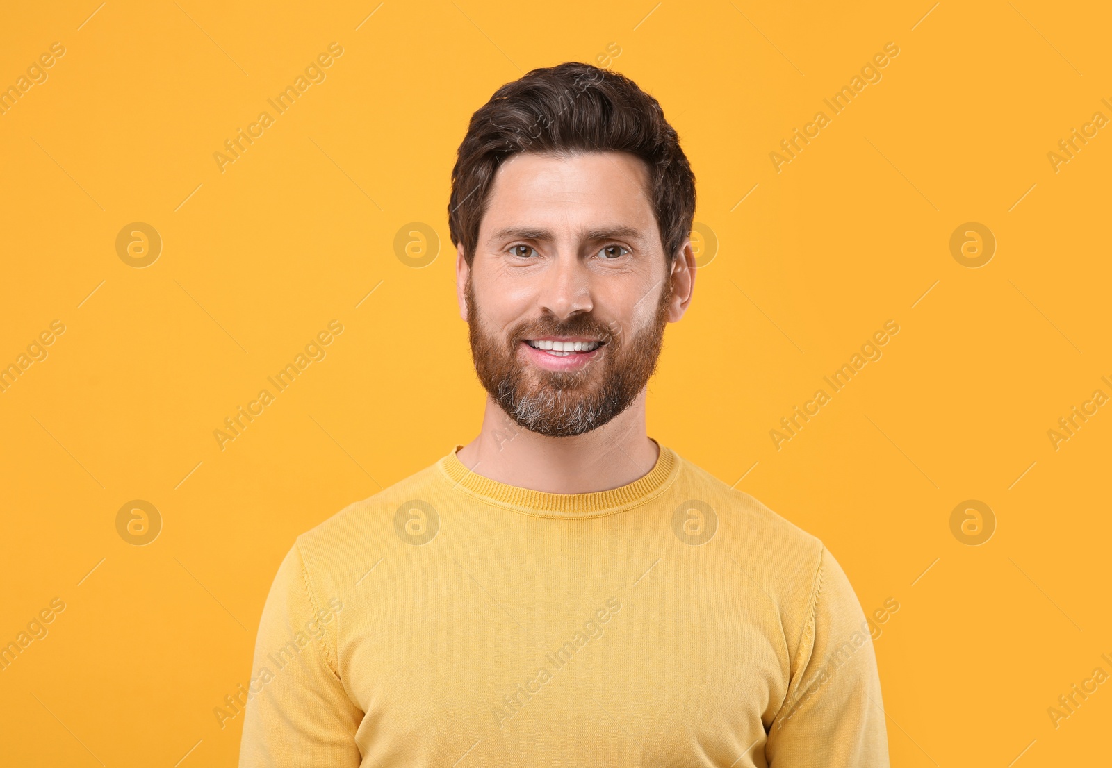 Photo of Portrait of handsome man on orange background