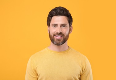 Photo of Portrait of handsome man on orange background