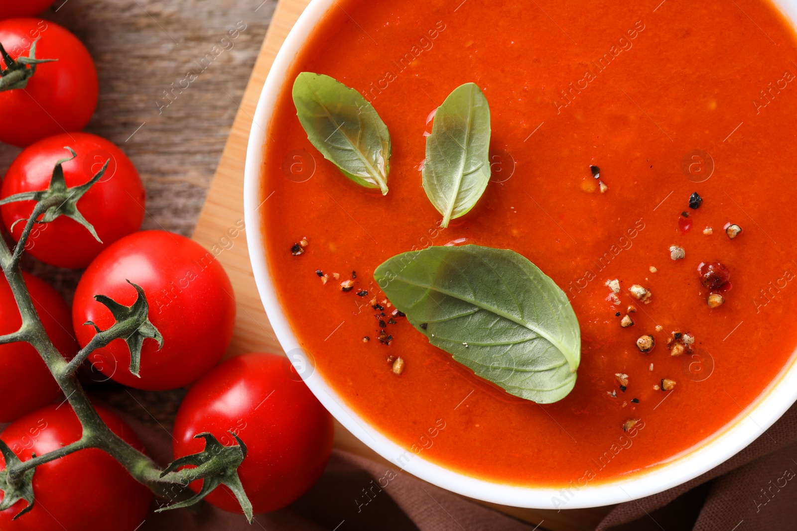 Photo of Delicious tomato soup on wooden table, flat lay