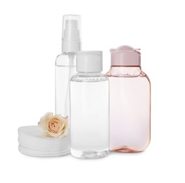 Photo of Bottles of micellar cleansing water, cotton pads and flower on white background