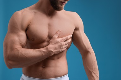 Photo of Muscular man on light blue background, closeup. Sexy body