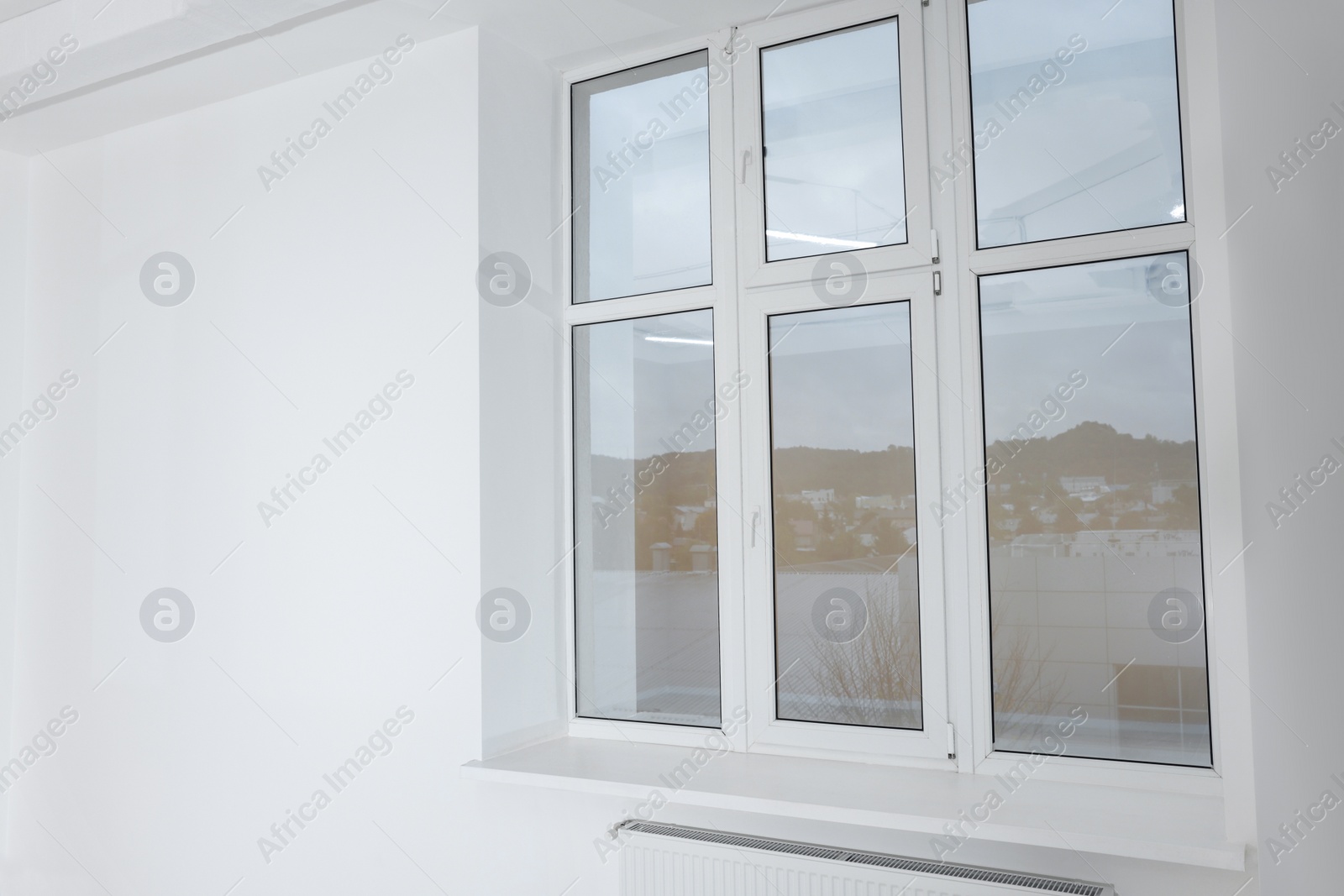 Photo of New empty room with clean windows and white wall